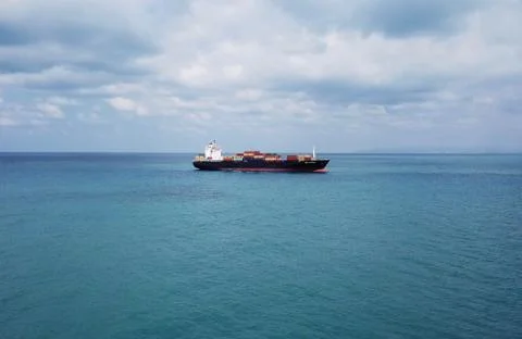 Huge large mega ULCV container ship sails on open water fully loaded Stock Photos