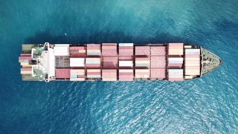 Huge large mega ULCV container ship sails on open water fully loaded Stock Photos