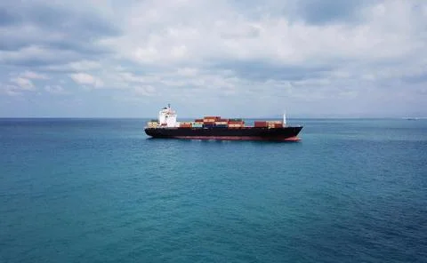 Huge large mega ULCV container ship sails on open water fully loaded Stock Photos