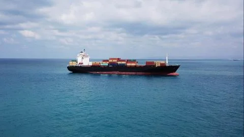 Huge large mega ULCV container ship sails on open water fully loaded Stock Photos