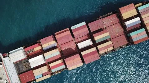 Huge large mega ULCV container ship sails on open water fully loaded Stock Photos