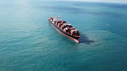 Huge large mega ULCV container ship sails on open water fully loaded Stock Photos