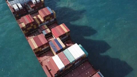 Huge large mega ULCV container ship sails on open water fully loaded Stock Photos