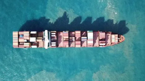 Huge large mega ULCV container ship sails on open water fully loaded Stock Photos