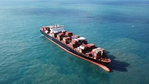 Huge large mega ULCV container ship sails on open water fully loaded Stock Photos