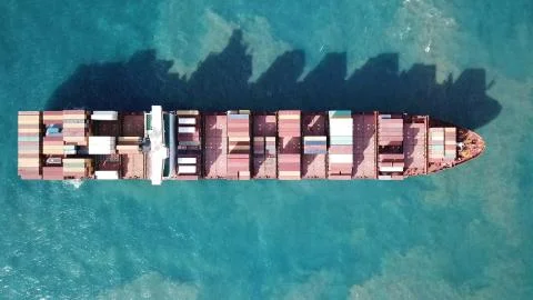 Huge large mega ULCV container ship sails on open water fully loaded Stock Photos
