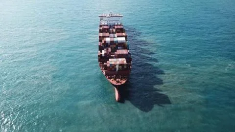 Huge large mega ULCV container ship sails on open water fully loaded Stock Photos