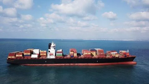 Huge large mega ULCV container ship sails on open water fully loaded Stock Photos