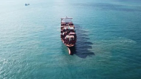 Huge large mega ULCV container ship sails on open water fully loaded Stock Photos