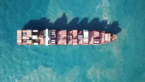 Huge large mega ULCV container ship sails on open water fully loaded Stock Photos