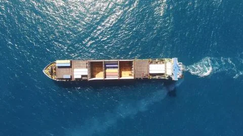 Huge large mega ULCV container ship sails on open water fully loaded Stock Photos