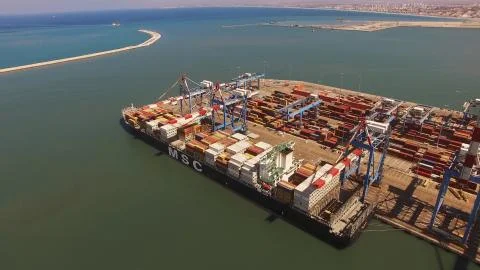 Huge large mega ULCV container ship sails on open water fully loaded Stock Photos