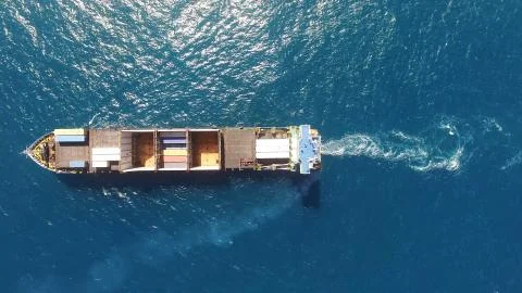 Huge large mega ULCV container ship sails on open water fully loaded Stock Photos