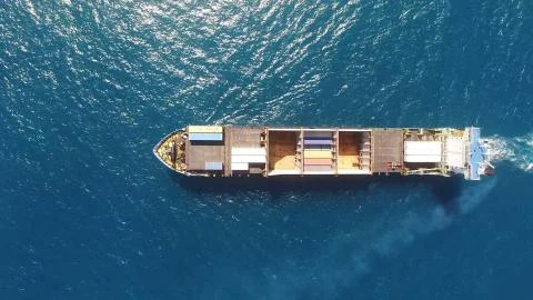 Huge large mega ULCV container ship sails on open water fully loaded Stock Photos