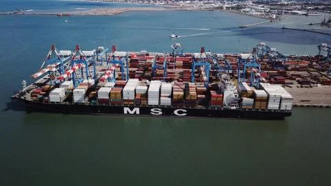 Huge large mega ULCV container ship sails on open water fully loaded Stock Photos