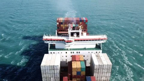 Huge large mega ULCV container ship sails on open water fully loaded Stock Photos