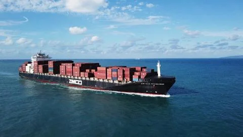 Huge large mega ULCV container ship sails on open water fully loaded Stock Photos