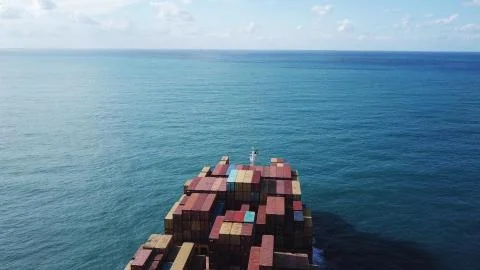 Huge large mega ULCV container ship sails on open water fully loaded Stock Photos