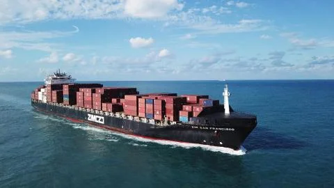 Huge large mega ULCV container ship sails on open water fully loaded Stock Photos
