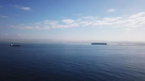 Huge large mega ULCV container ship sails on open water fully loaded Stock Photos