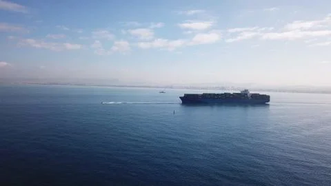Huge large mega ULCV container ship sails on open water fully loaded Stock Photos