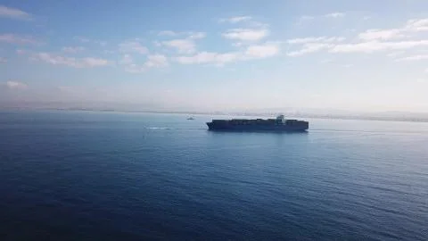 Huge large mega ULCV container ship sails on open water fully loaded Stock Photos