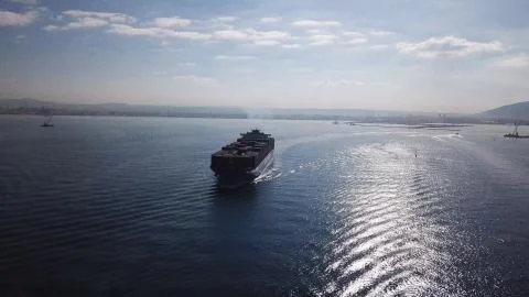 Huge large mega ULCV container ship sails on open water fully loaded Stock Photos