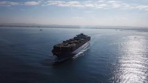 Huge large mega ULCV container ship sails on open water fully loaded Stock Photos