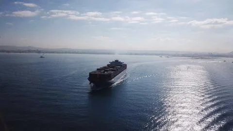 Huge large mega ULCV container ship sails on open water fully loaded Stock Photos