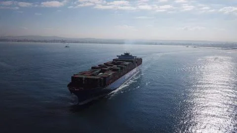 Huge large mega ULCV container ship sails on open water fully loaded Stock Photos