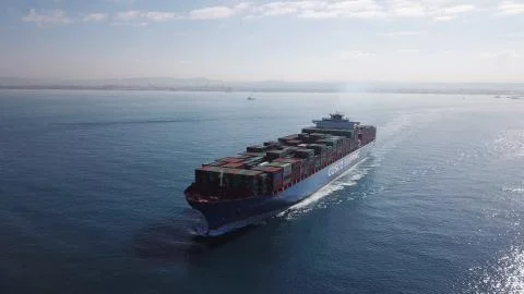 Huge large mega ULCV container ship sails on open water fully loaded Stock Photos