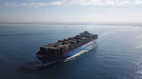 Huge large mega ULCV container ship sails on open water fully loaded Stock Photos