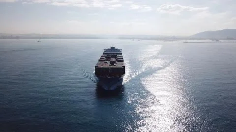 Huge large mega ULCV container ship sails on open water fully loaded Stock Photos