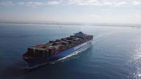 Huge large mega ULCV container ship sails on open water fully loaded Stock Photos