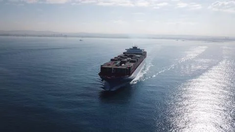 Huge large mega ULCV container ship sails on open water fully loaded Stock Photos