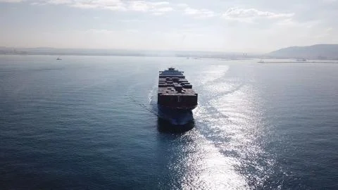Huge large mega ULCV container ship sails on open water fully loaded Stock Photos