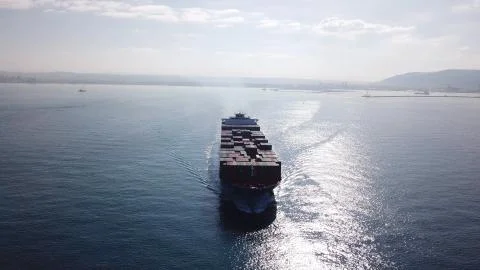 Huge large mega ULCV container ship sails on open water fully loaded Stock Photos