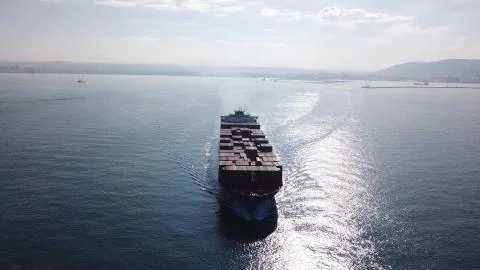 Huge large mega ULCV container ship sails on open water fully loaded Stock Photos