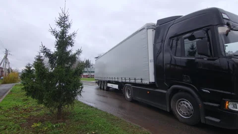 Huge lorry with long trailer drives along road on autumn day Видео 329381394