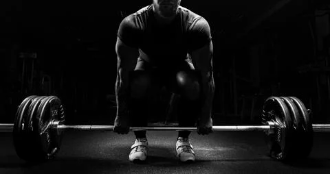 Huge man is preparing to perform an exercise called deadlift. Stock Photos