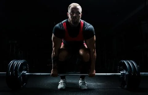 Huge man is preparing to perform an exercise called deadlift. Stock Photos