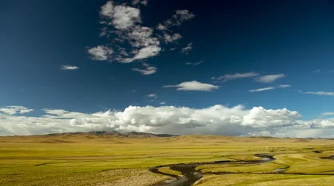 Huge meadow against backdrop of mountains, river and blue sky with clouds Stock Footage 51497155