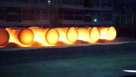 Huge metal rods lie in rows in the dark workshop blue sparks run on them Stock Footage 115928107