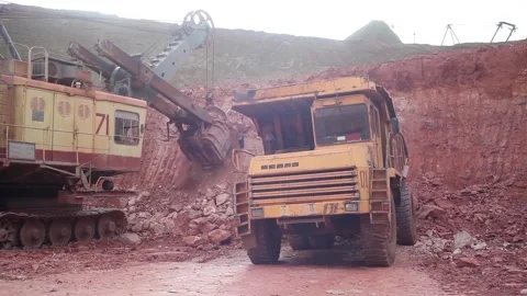 A huge mining excavator loads a large quarry multi-ton dump truck. Stock Footage 122217941