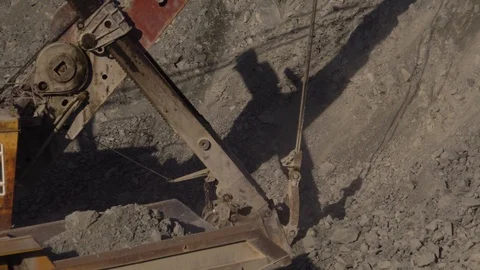 A huge mining excavator pours soil into the body of a large multi-ton yellow Stock Footage 125576904
