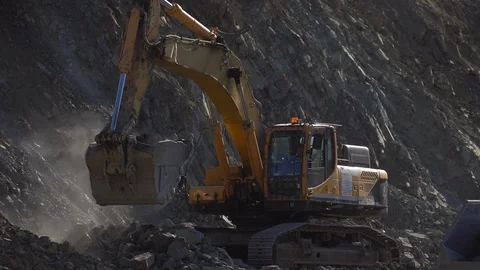 A huge mining excavator pours soil into the body of a large multi-ton yellow Stock Footage 125577598