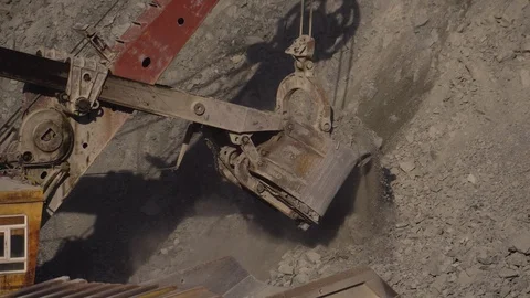 A huge mining excavator pours soil into the body of a large multi-ton yellow Stock Footage 125578413