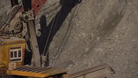 A huge mining excavator pours soil into the body of a large multi-ton yellow Stock Footage 125579075