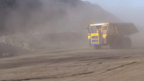 Huge mining truck rides on a quarry. The truck rides on off-road raising clouds Stock Footage 94371069
