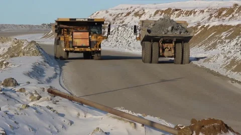 A huge mining truck working in a quarry. Two dump trucks are driving Stock Footage 122686382